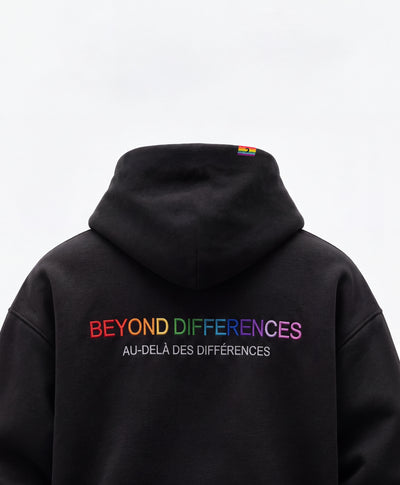 Back of the black Heavyweight Hoodie: rainbow BEYOND DIFFERENCES / AU-DELÀ DES DIFFÉRENCES embroidery