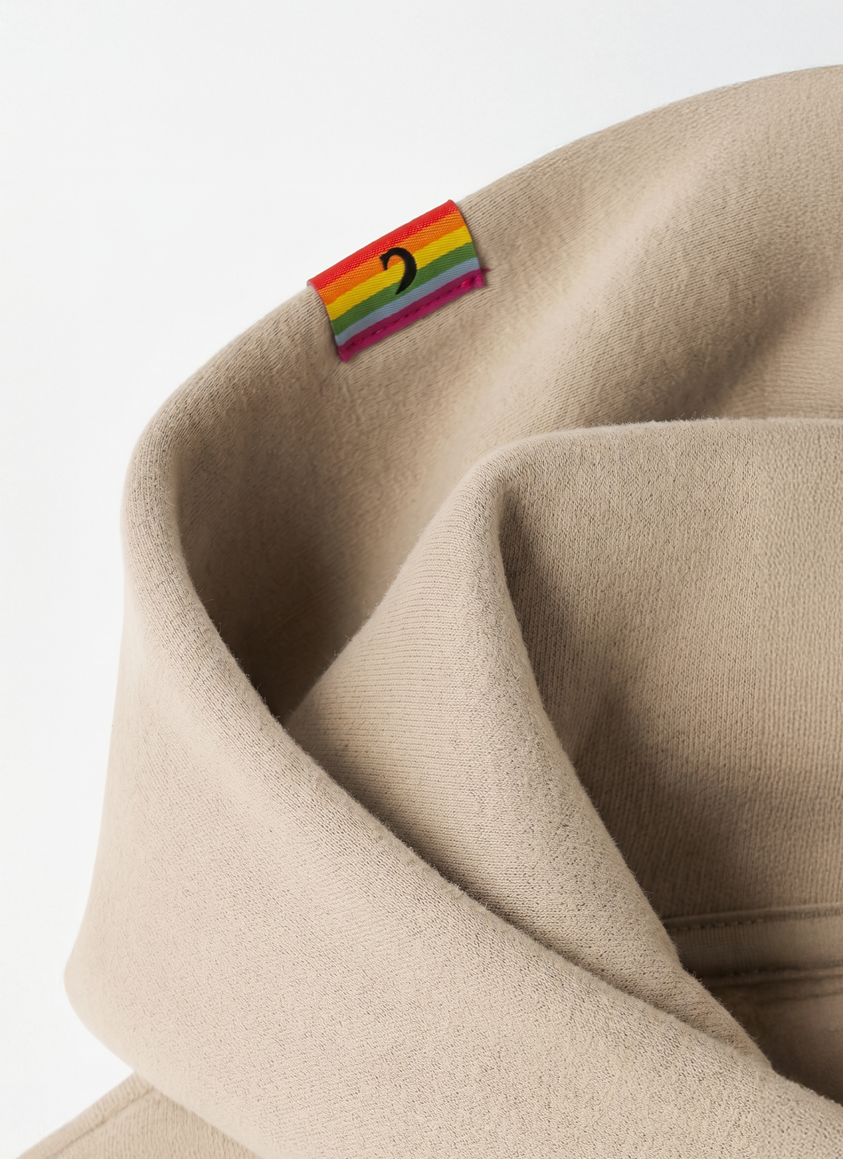 Rainbow flag tag stitched on the hood of a Sand Diversity hoodie