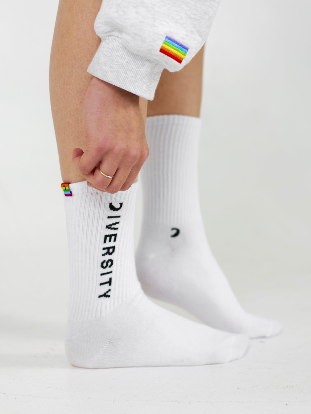 Person pulling on the white Diversity socks