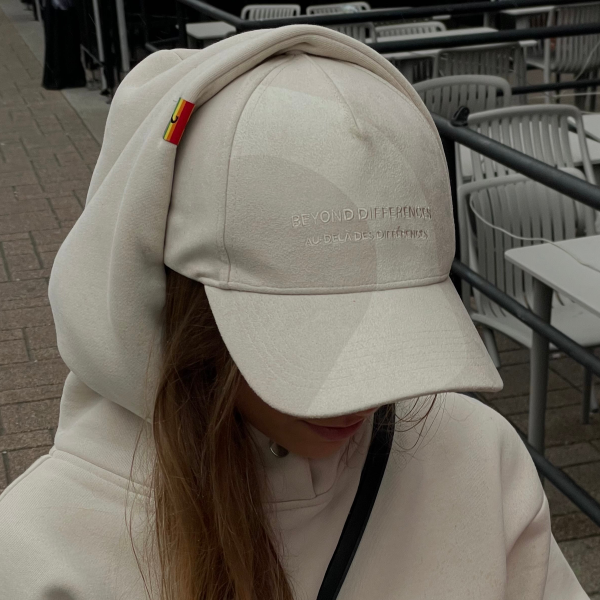Casquette beige en suède végane portée par-dessus un capuchon beige