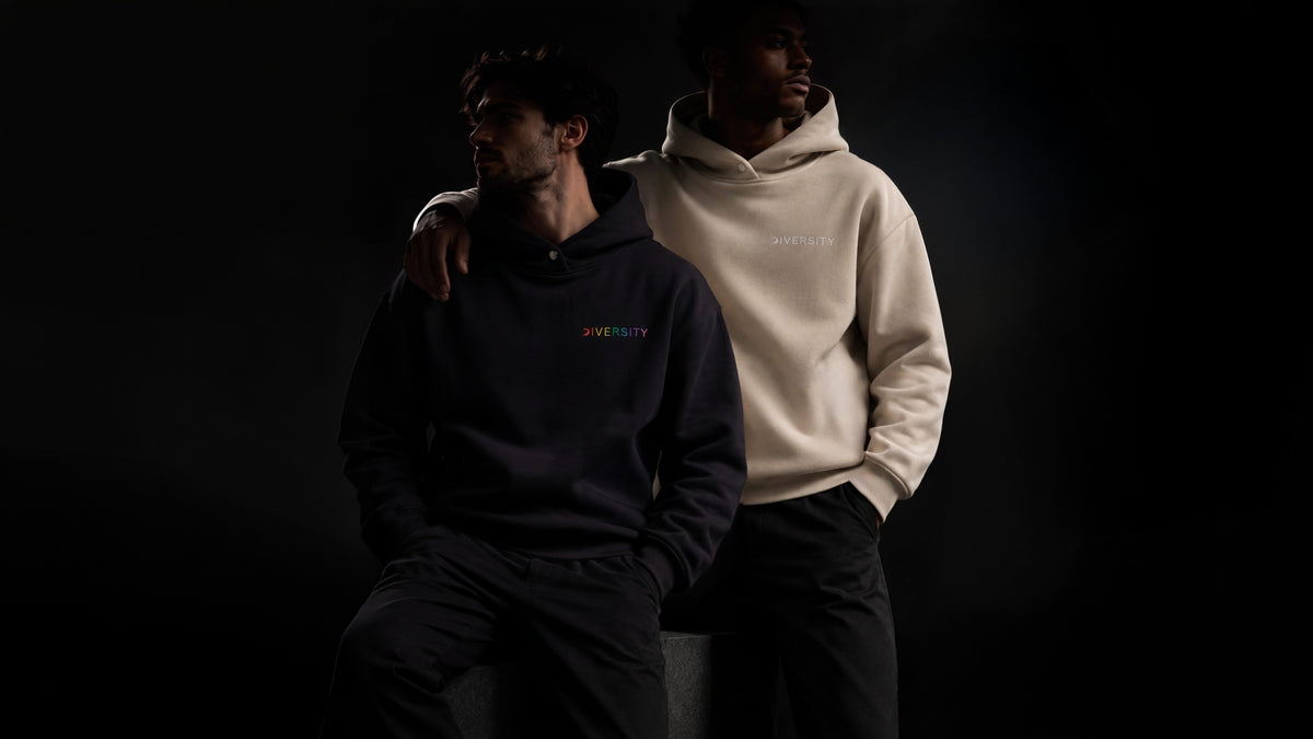 Deux personnes en Heavyweight Hoodie Noir et Beige Diversity, éclairage sombre