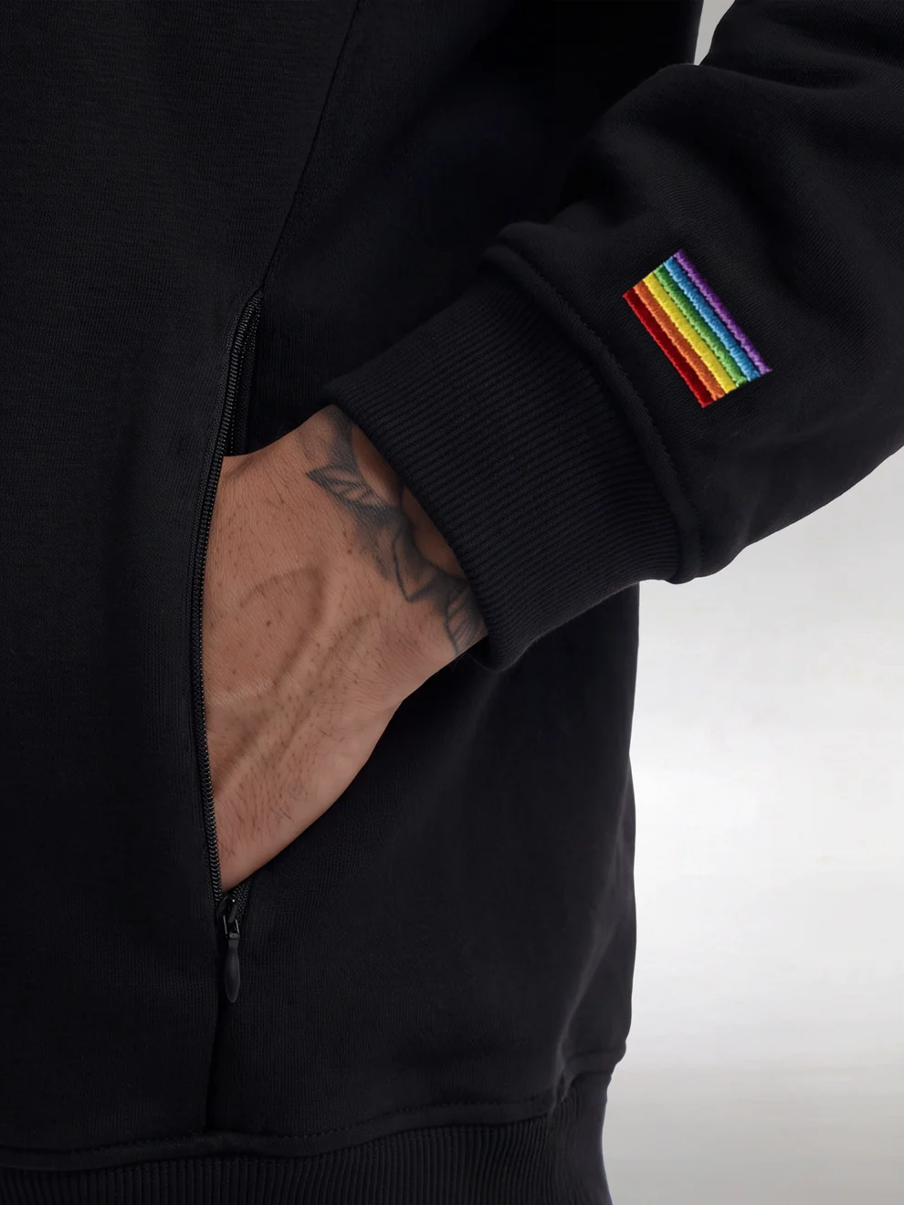 Hidden zip pocket and rainbow flag embroidered on the sleeve of the black Heavyweight Hoodie
