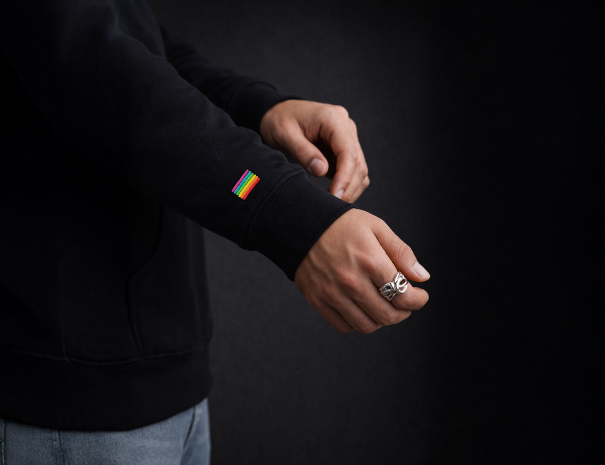 Drapeau arc-en-ciel brodé sur la manche d'un hoodie noir Diversity