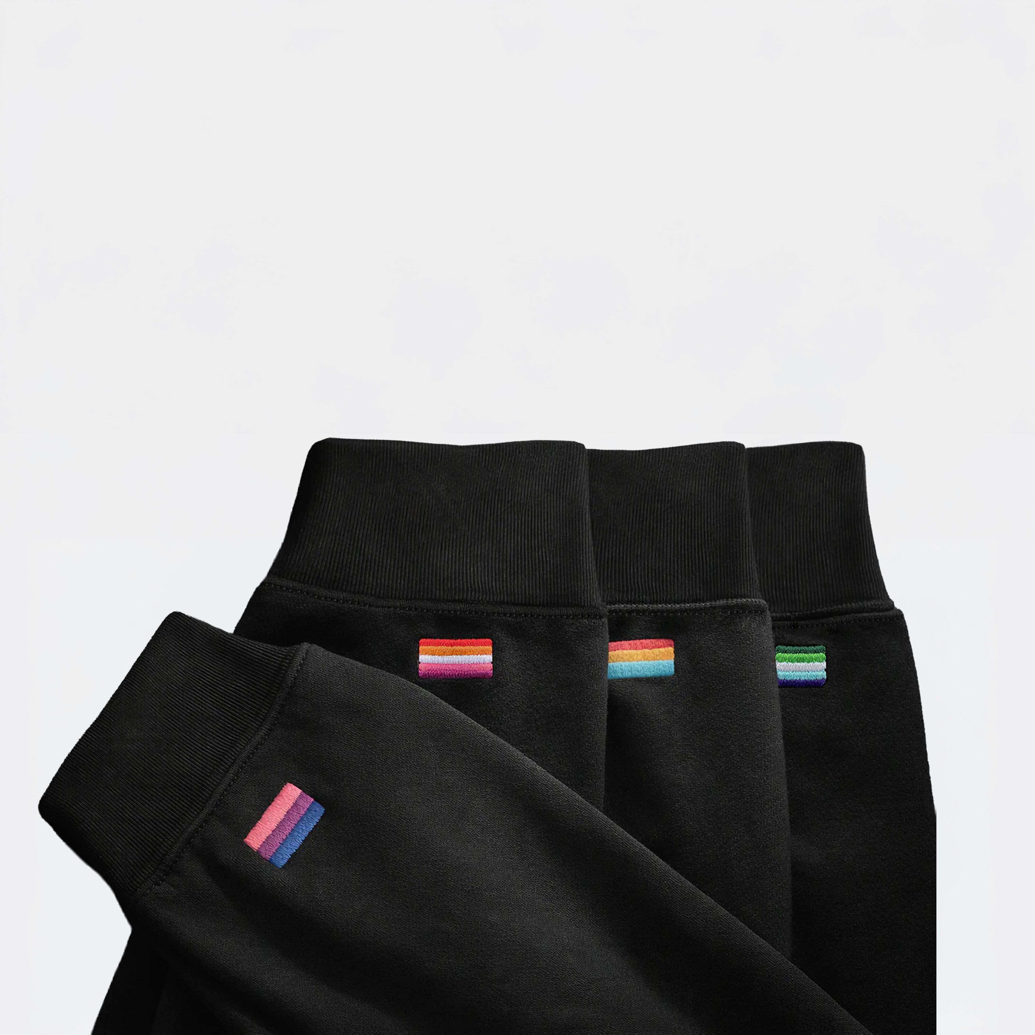 Sleeves of black midweight pieces with different embroidered pride flags