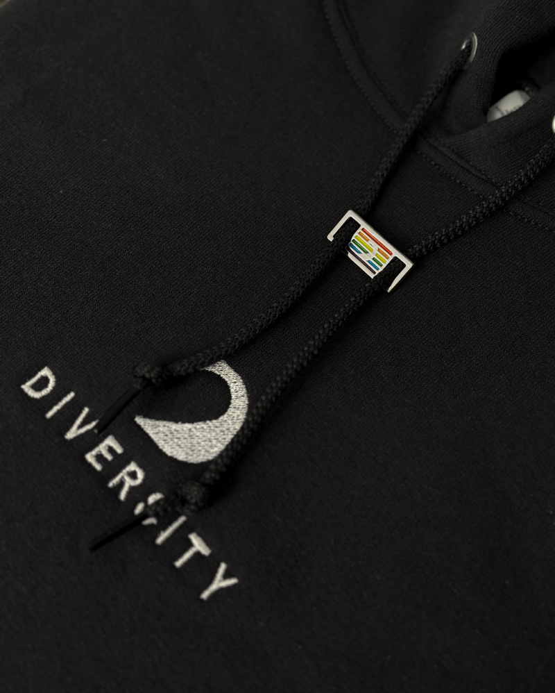 Rainbow D'Lux pin on the drawstring of a black Diversity hoodie